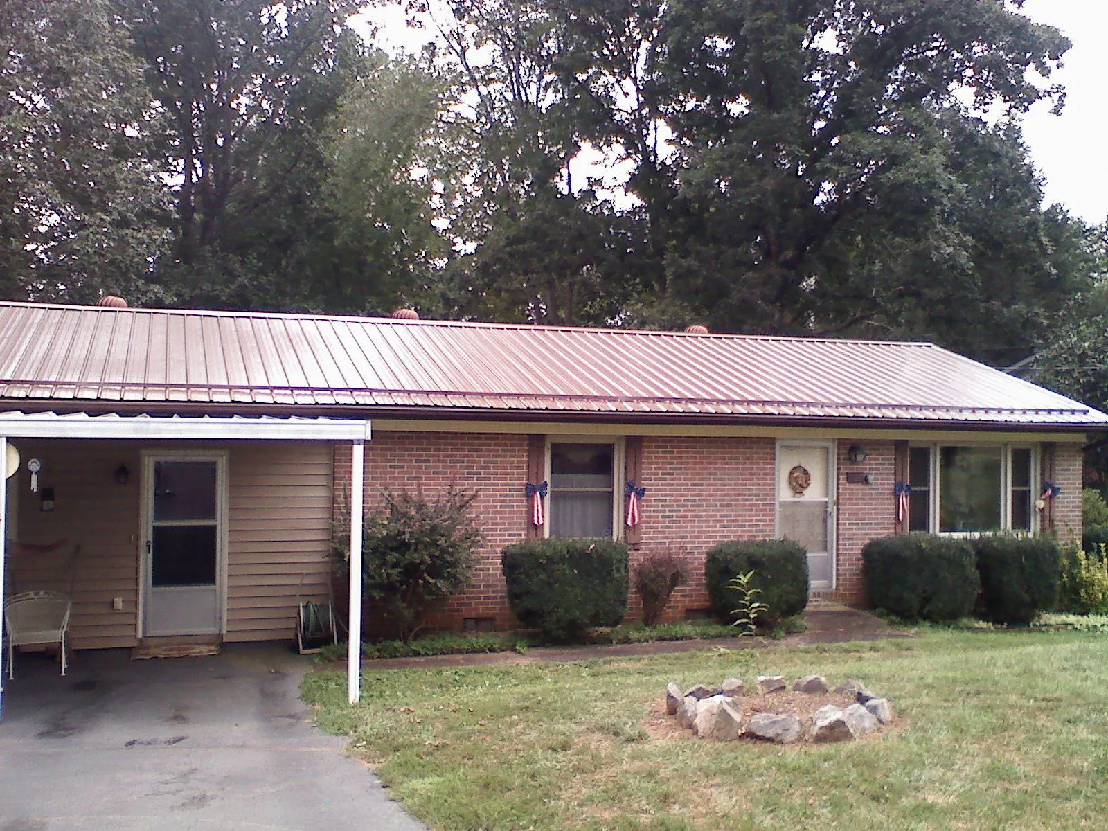 Bronze metal roof and carport on a brick ranch home — Roof Repair work by our crew in Clarkson