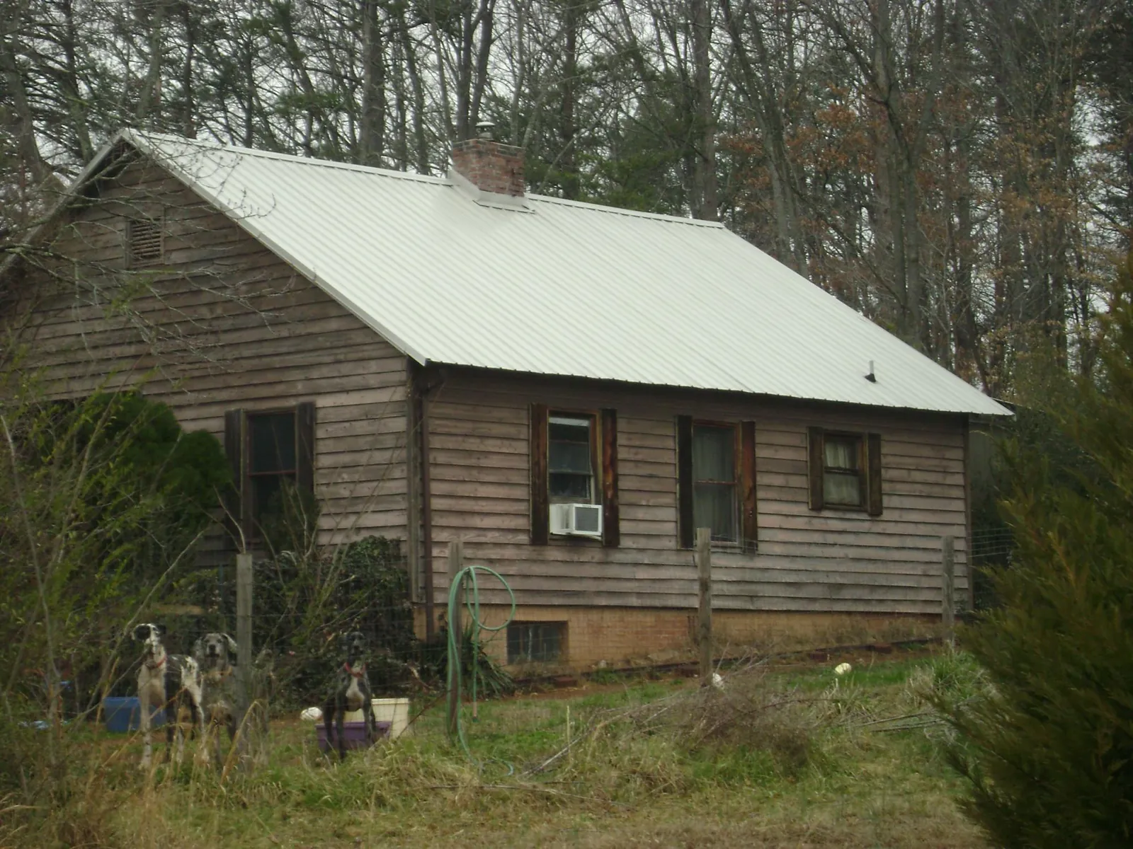 White metal roof on an old wood sided farmhouse, from a Metal Roof Installation job in Clarkson